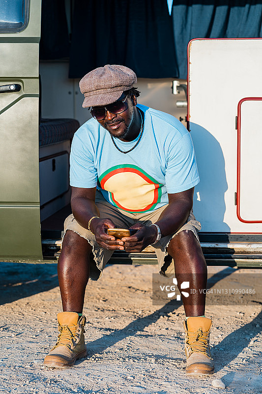 黑人男子戴眼镜在露营车里使用手机图片素材