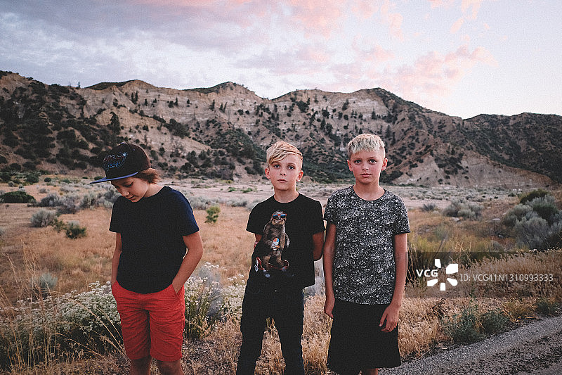 夕阳下库亚马山谷路边的三个男孩图片素材