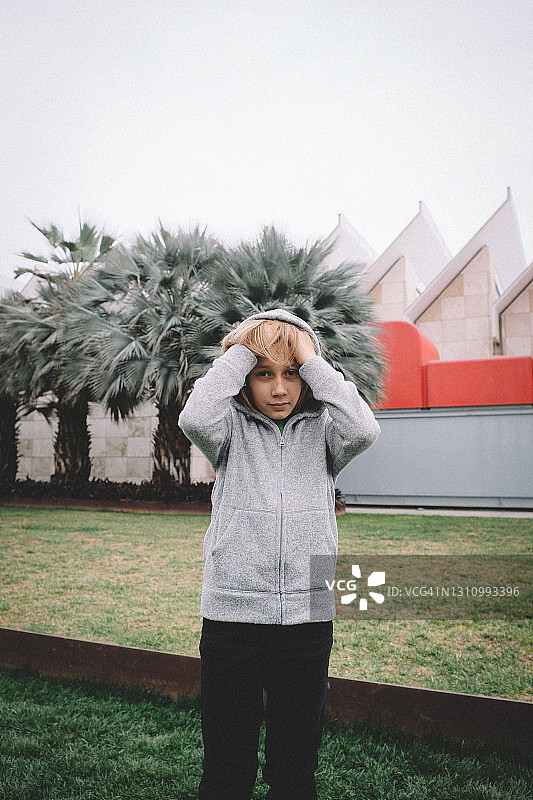 沮丧地用手指梳理头发的男孩图片素材