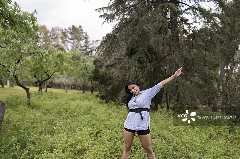 在自然环境中举起双臂的拉丁美洲女性图片素材