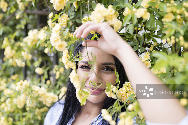 在黄色春花中微笑的美丽拉丁美洲女人图片素材