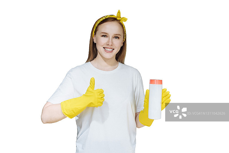 手持清洁产品，面带微笑的年轻家庭主妇图片素材