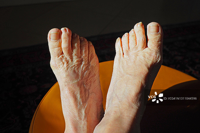 老年妇女的脚部特写，深色背景图片素材