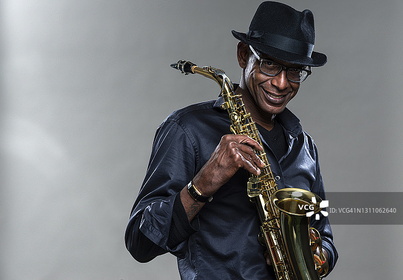 带着灿烂笑容演奏萨克斯的音乐家图片素材