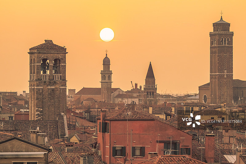 意大利威尼托威尼斯在阴沉的日落时分，教堂钟楼从周围的房屋升起图片素材