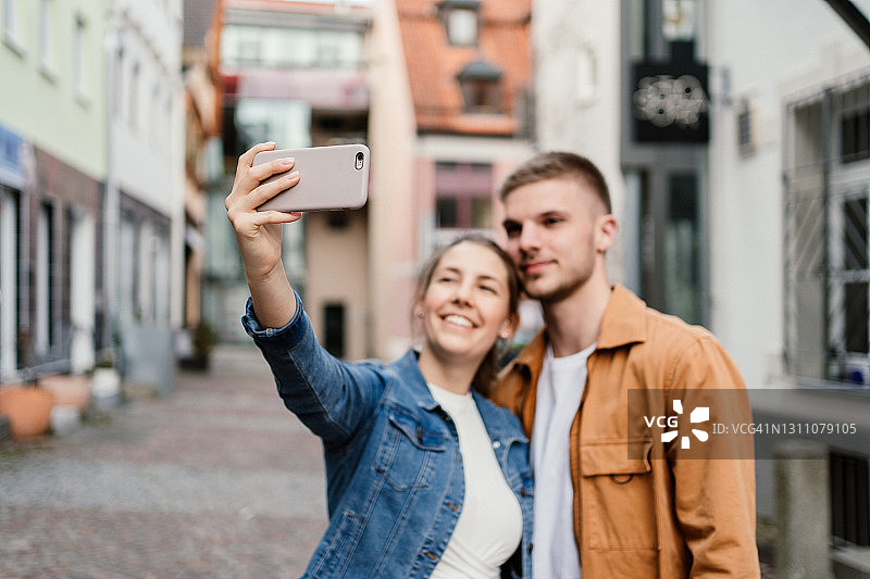 年轻夫妇用智能手机自拍图片素材