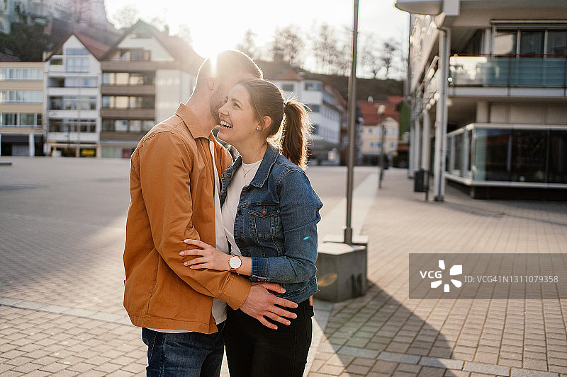 年轻情侣在市中心空旷的广场上调情图片素材