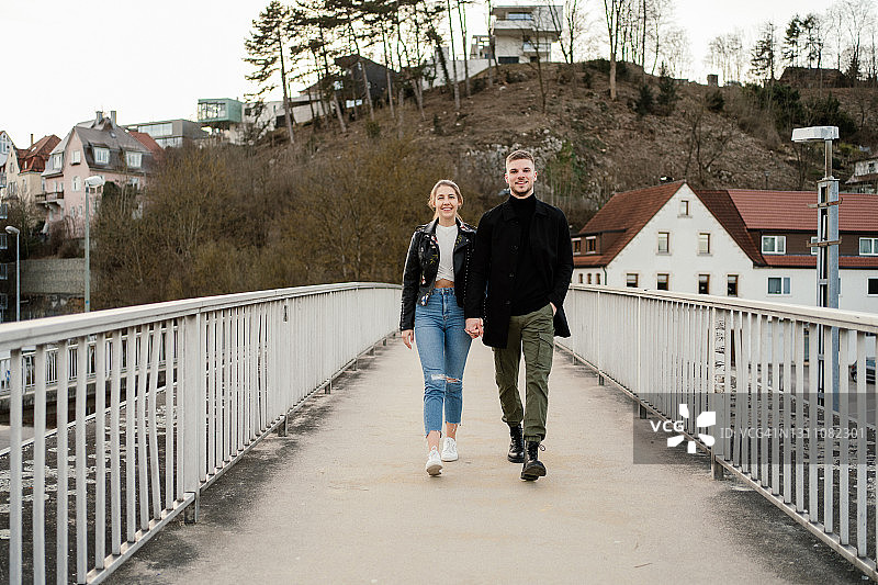 年轻情侣在步行桥上图片素材