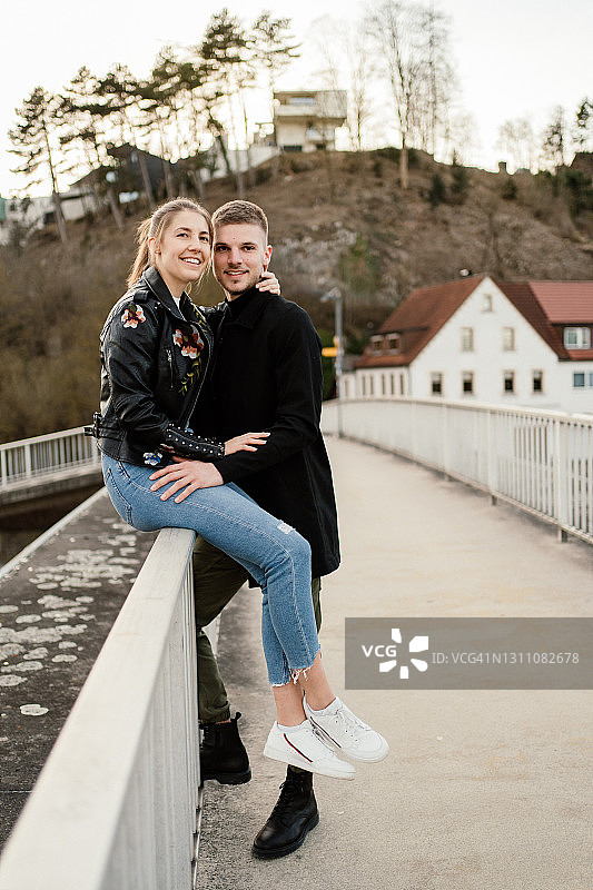 年轻情侣在步行桥上图片素材