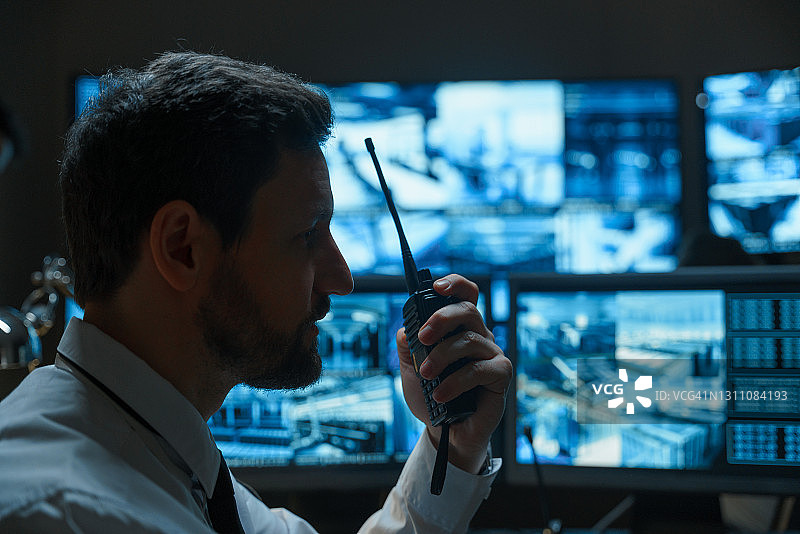 留着胡子的保安或警察正在用对讲机讲话图片素材