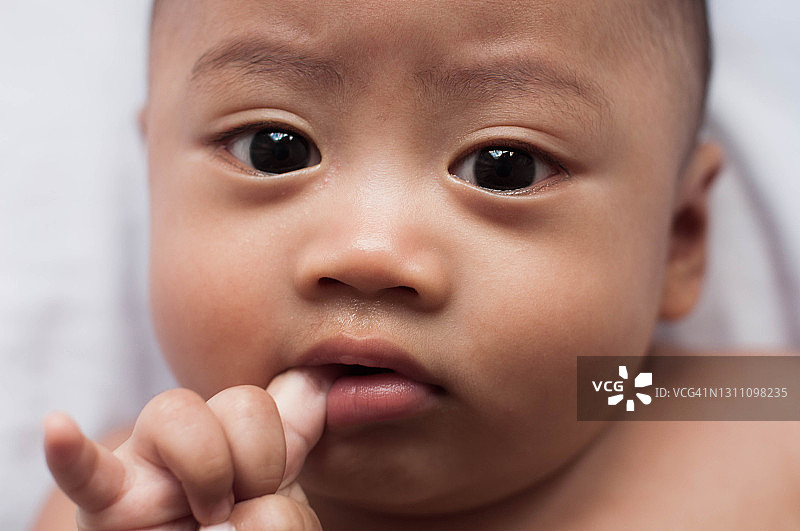 东南亚男婴躺在床上的肖像图片素材