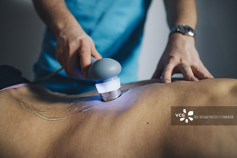 理疗师使用超声波治疗患者背部图片素材