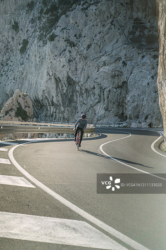 清晨在沿海公路上骑行的年轻人图片素材