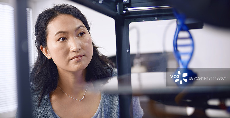 女生物医学工程师正在观察DNA结构模型图片素材