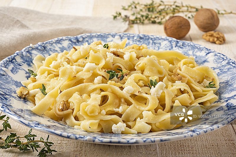 新鲜自制意大利宽面配羊乳酪和核桃图片素材