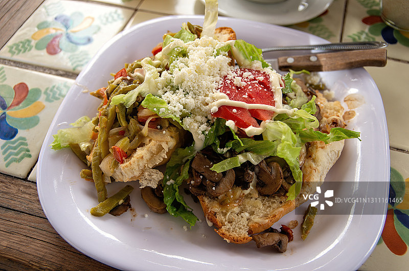 墨西哥式烤面包，一面是仙人掌，西红柿和洋葱，另一面是炸蘑菇图片素材