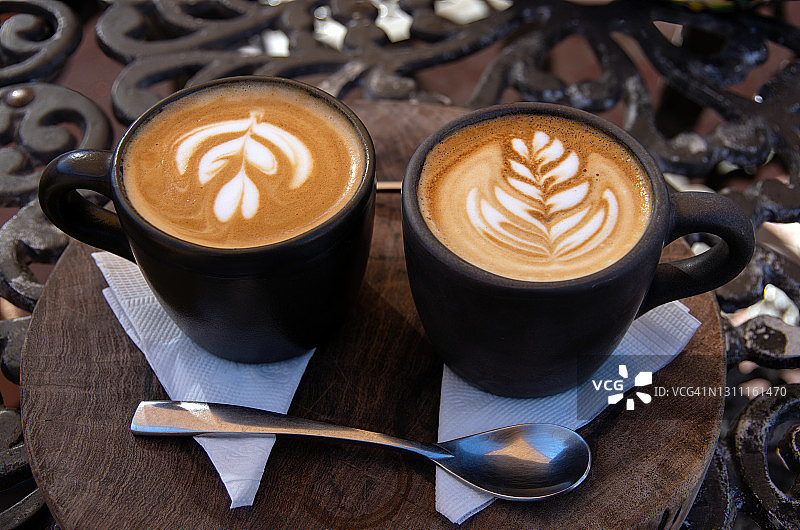 木块和铁艺桌上的两杯馥芮白咖啡图片素材