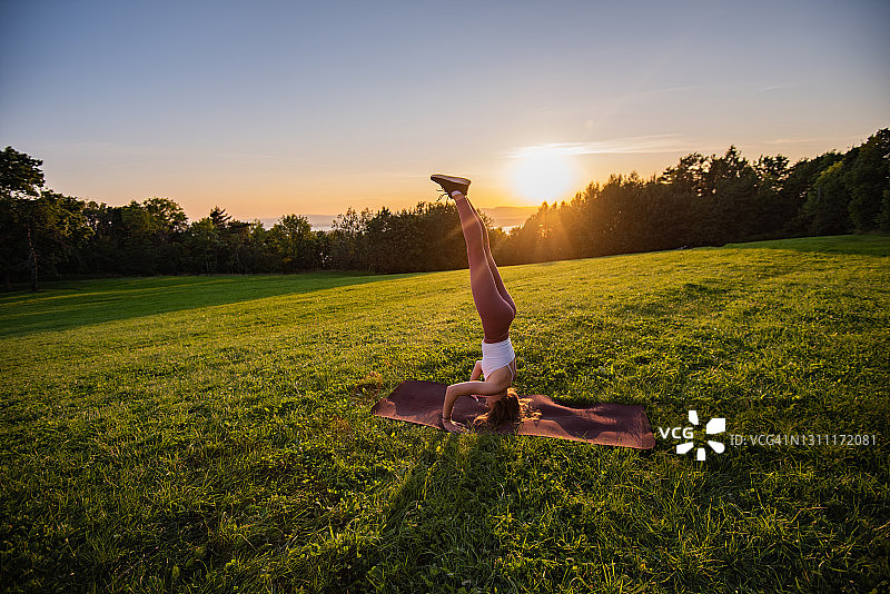 年轻女子在户外做头倒立式图片素材