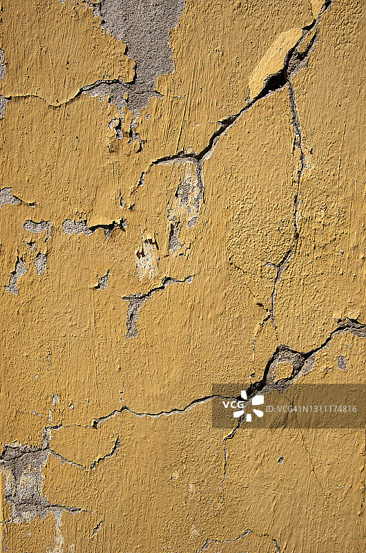 黄色油漆剥落的混凝土裂纹灰泥墙图片素材