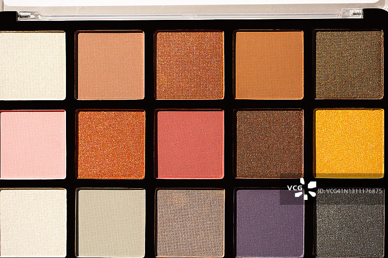 黑色调色板中用于日常妆容的多种彩色眼影，包括黄色、金色、古铜色、米色、灰色、棕色、浅粉色和紫色图片素材