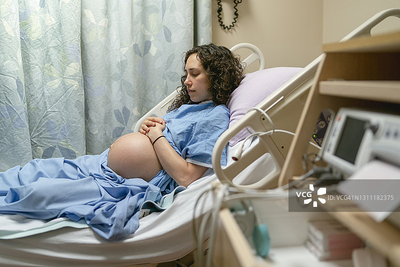孕妇躺在医院病床上准备分娩图片素材
