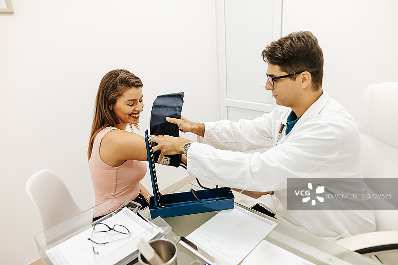年轻女患者在医生办公室测量血压图片素材