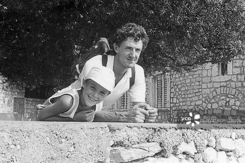 父子在墙边眺望图片素材