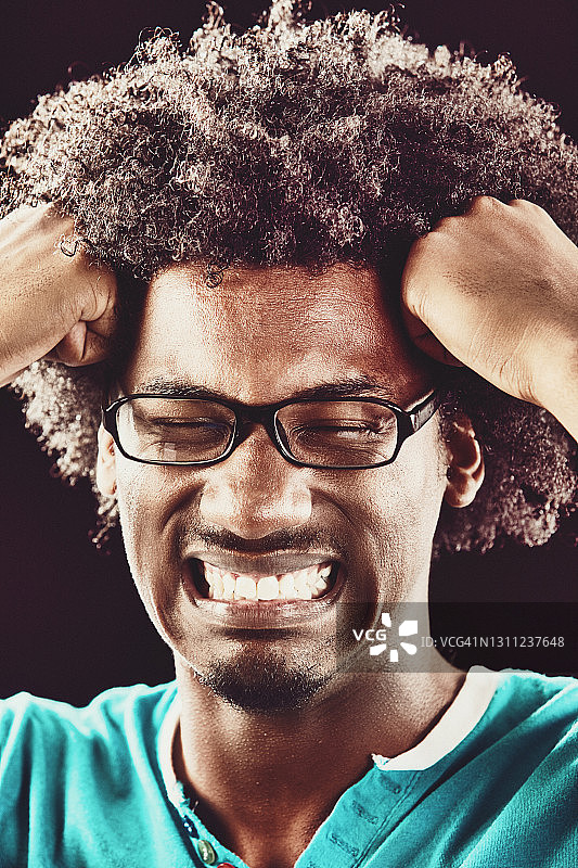 绝望的男人用拳头按住太阳穴，因悲伤或痛苦而面露痛苦图片素材