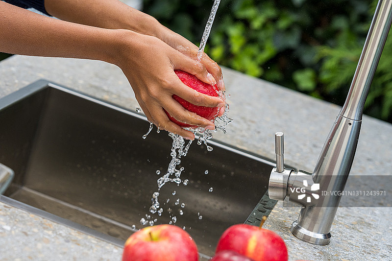女人在花园水槽里洗苹果图片素材