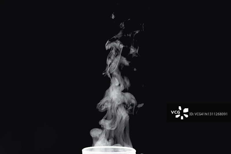 黑色背景上茶或咖啡的白色抽象蒸汽图片素材