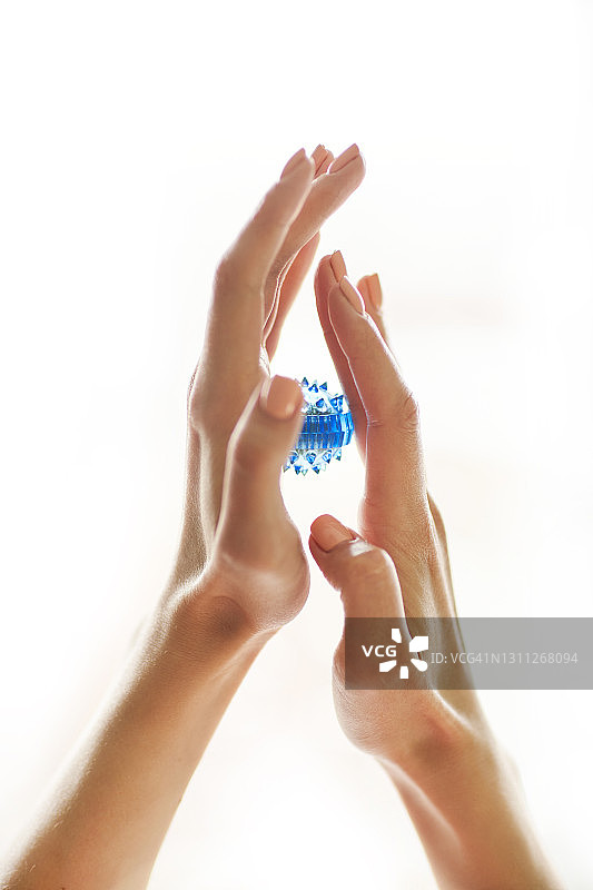 手和女性手中的手指按摩器“SU JOK”，白色背景图片素材