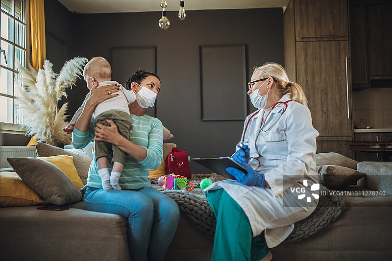 居家隔离期间，女儿科医生上门为新生儿检查图片素材