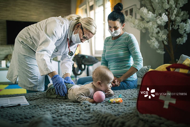 居家隔离期间，女儿科医生上门为新生儿检查图片素材