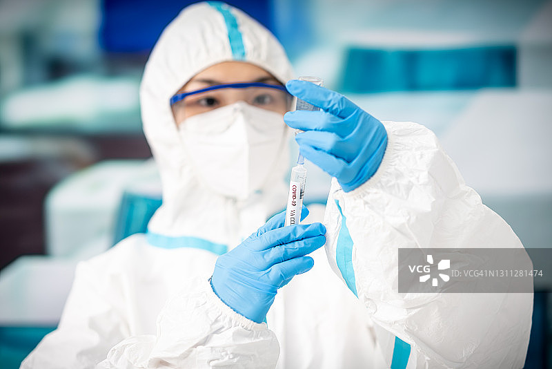 拿着新冠疫苗和注射器的女医生图片素材