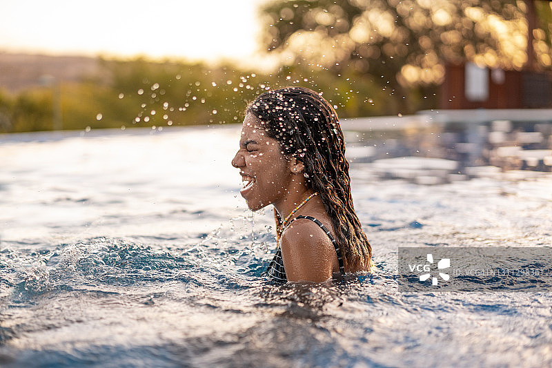 日落时参加泳池派对的少女图片素材