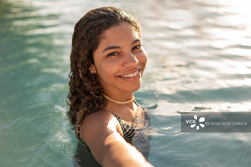 少女在日出时的泳池自拍图片素材