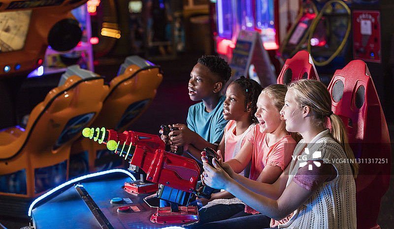 四个孩子在玩街机游戏图片素材