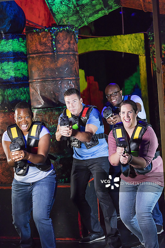 四个多种族成年人玩激光标签游戏图片素材