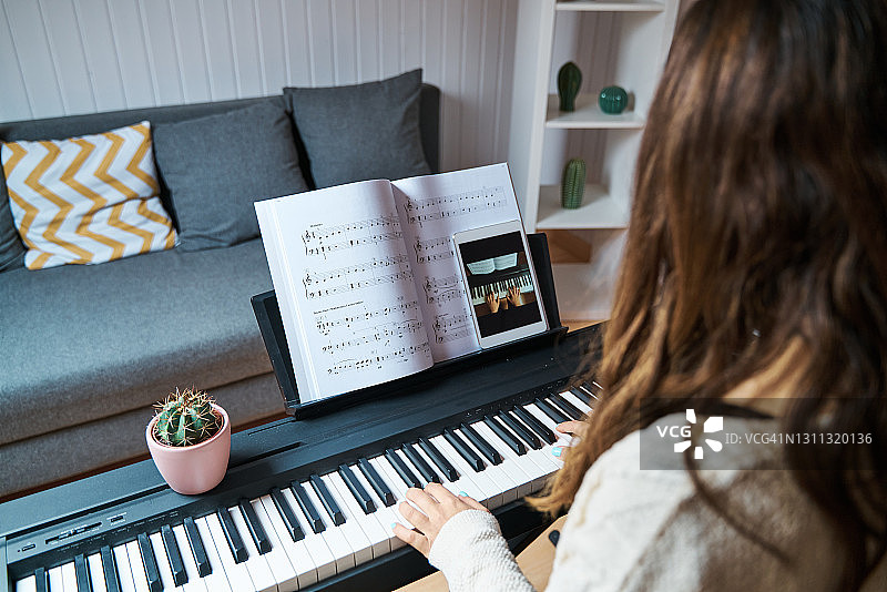 女人在家中上在线钢琴课图片素材