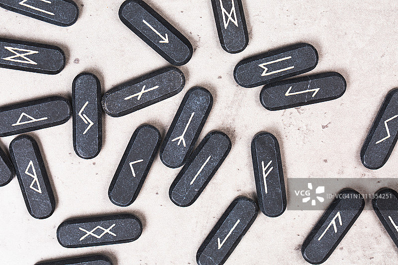 混凝土灰色背景上的石头符文，魔法深奥仪式概念，2021年度流行色，顶部桌面视图和超特写图片素材