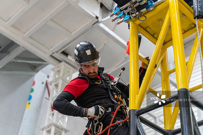 穿防护服高空作业的年轻男人图片素材