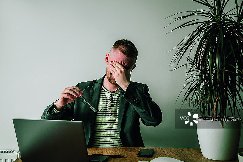 疲惫的商人与笔记本电脑图片素材