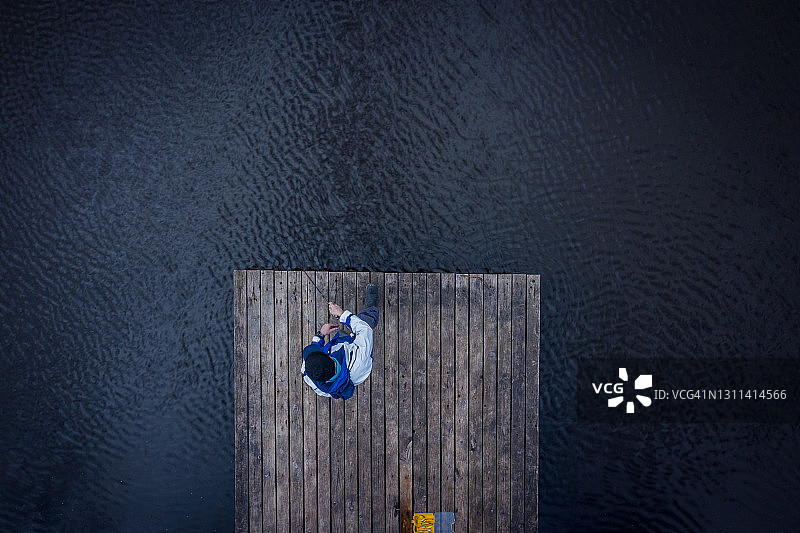 男人在木桥上钓鱼图片素材