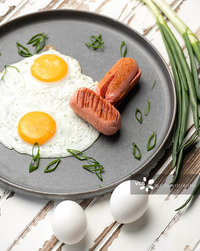 平底锅里的香肠葱花煎蛋：经典美式或英式乡村早餐图片素材