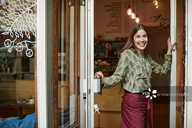 咖啡店老板站在门口看向镜头的肖像图片素材