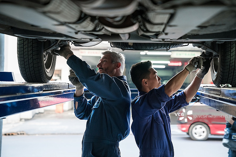 汽车机械师检查车辆底盘图片素材