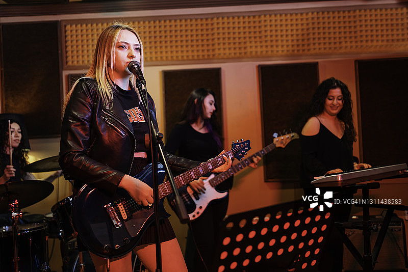 当代乐队在工作室排练的半身像图片素材