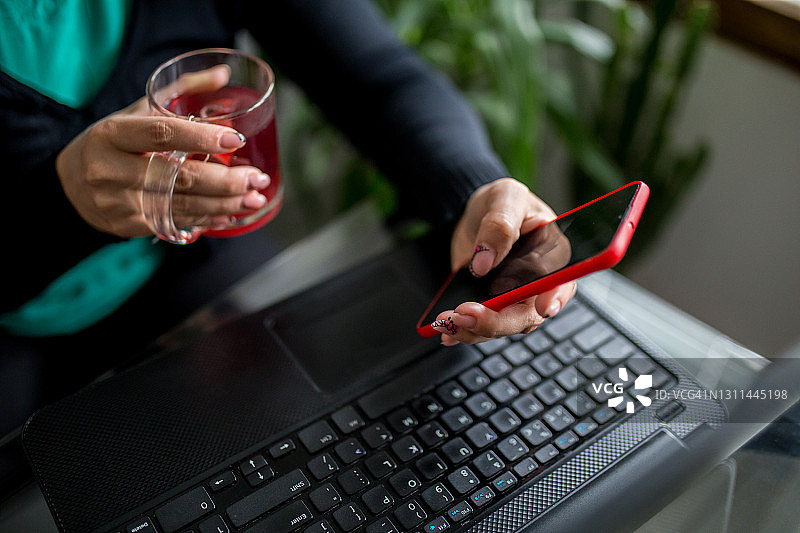 早晨使用手机和笔记本电脑的女人图片素材