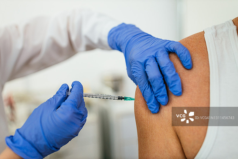 女护士为老年患者接种新冠疫苗图片素材