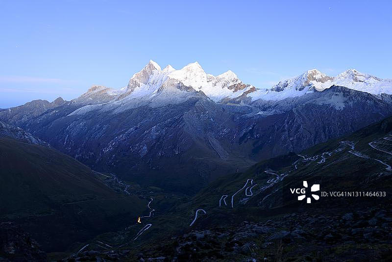 清晨蜿蜒的山路和万多伊山，秘鲁云盖省的布兰卡山脉图片素材